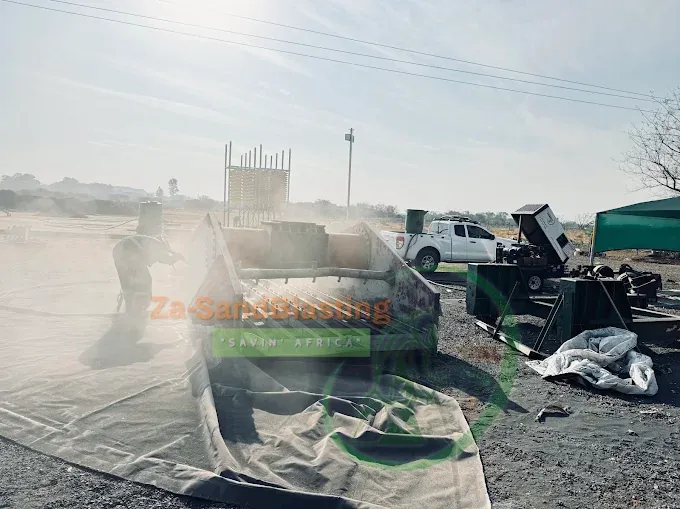 Mobile sandblasting of a container with a dust cloud on an open site
