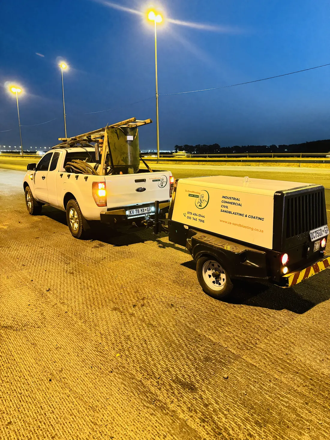 Za-SandBlasting mobile rig: bakkie and diesel compressor set up for on-site blasting at dusk