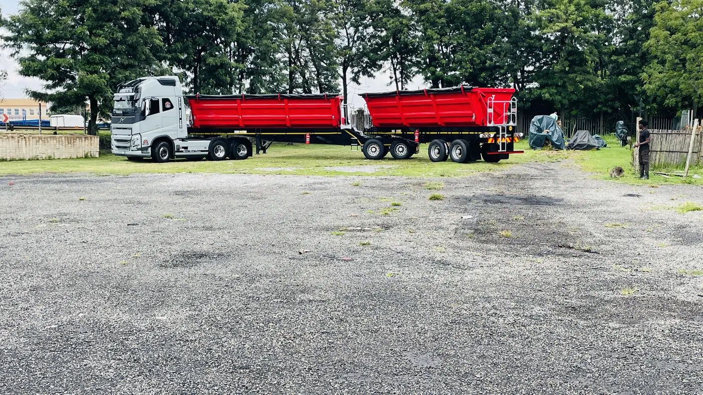 Red tipper truck trailers parked on a yard after rust removal sandblasting